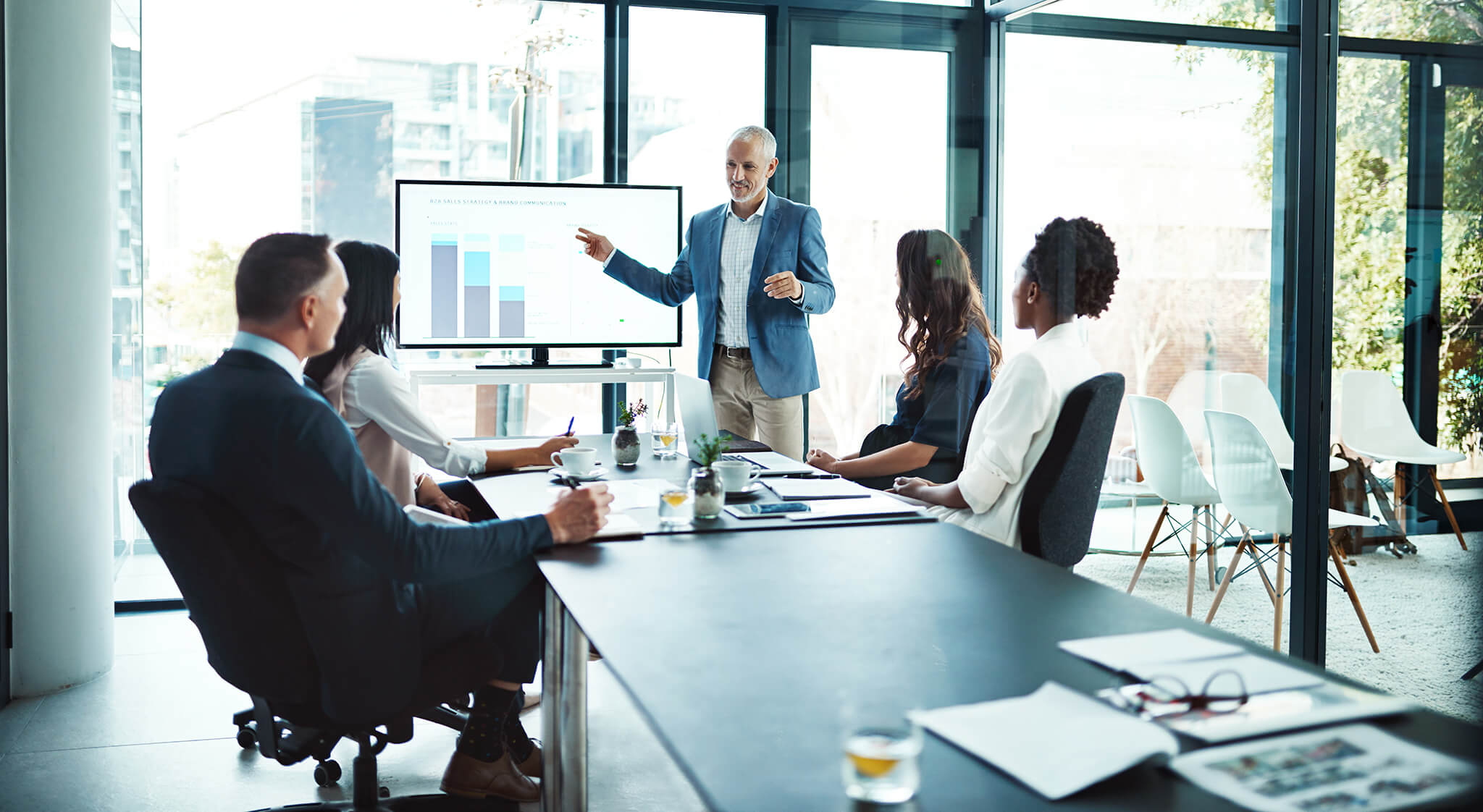 An image of office workers in a conference room collaborating on strategy.